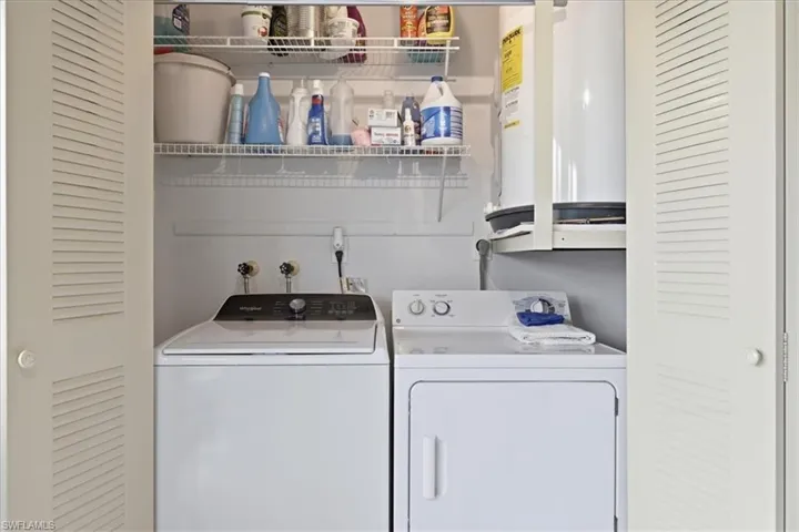 Laundry area featuring electric water heater and washing machine and clothes dryer