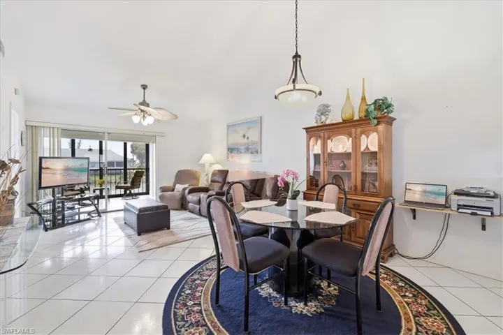 Dining room featuring a ceiling fan, light tile patterned flooring, and lofted ceiling