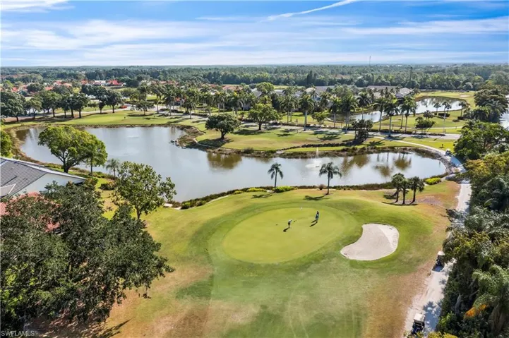 Aerial perspective of suburban area featuring a large body of water and a golf course