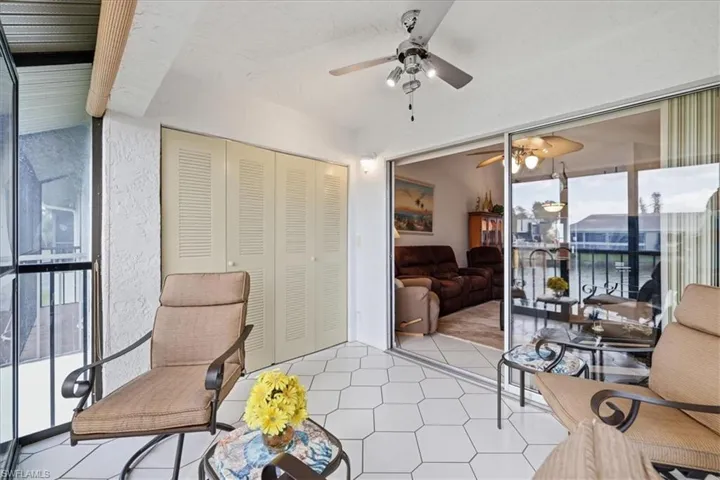 Sitting room with ceiling fan and floor to ceiling windows