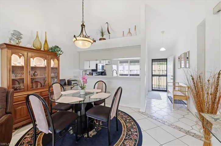 Dining room featuring light tile patterned floors and a high ceiling