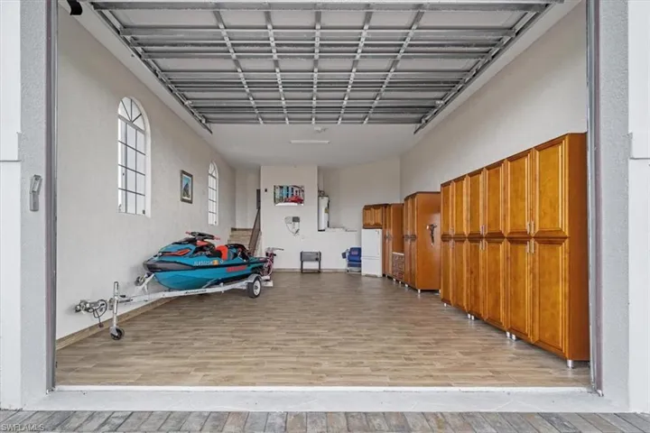 Garage with a textured wall and freestanding refrigerator