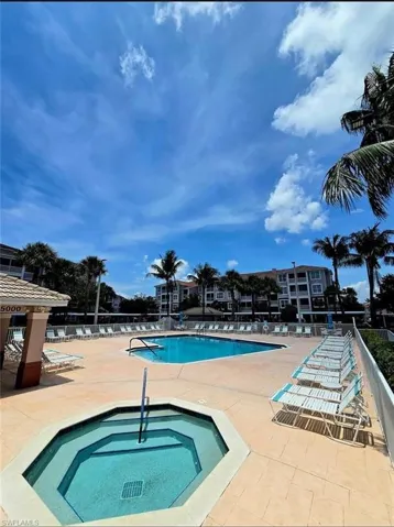 Community pool with a hot tub and a patio area