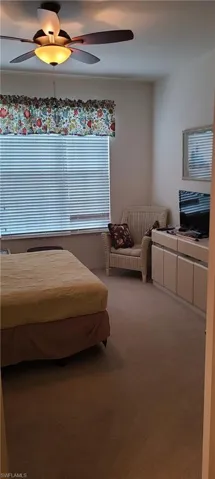 Carpeted bedroom featuring ceiling fan