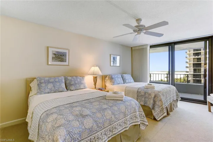 Guest suite with 2 Queen beds and entrance to balcony with beach/gulf view