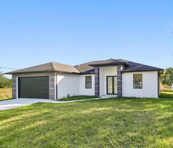 Prairie-style home featuring a garage and a front lawn