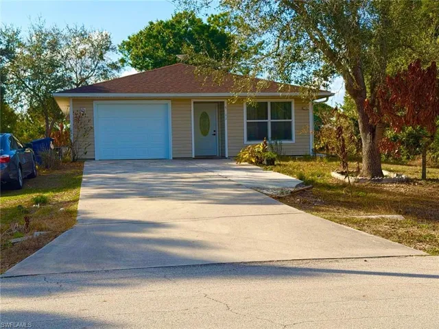 View of front facade featuring a garage and concrete driveway