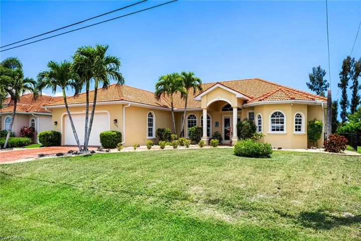 View of front of property featuring a garage and a front lawn