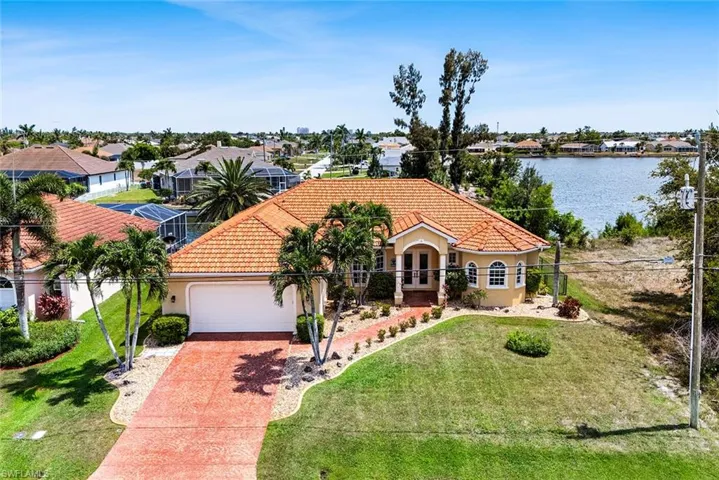 Mediterranean / spanish home featuring a front lawn, a garage, and a water view