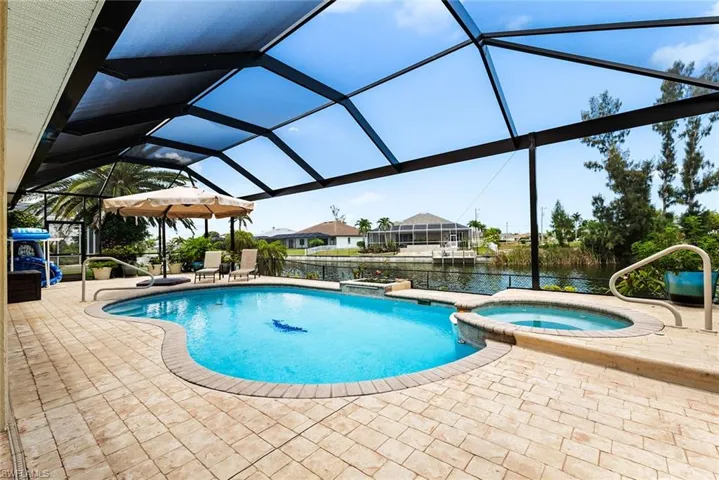 View of pool with a lanai, an in ground hot tub, and a patio area