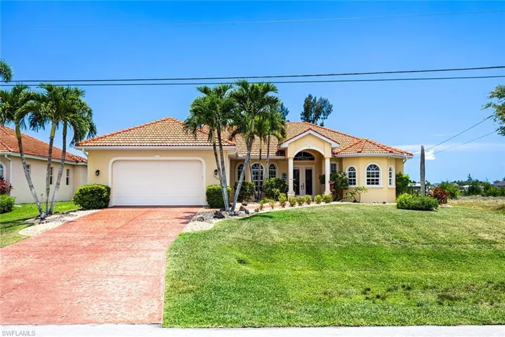 Mediterranean / spanish-style home with a garage and a front lawn