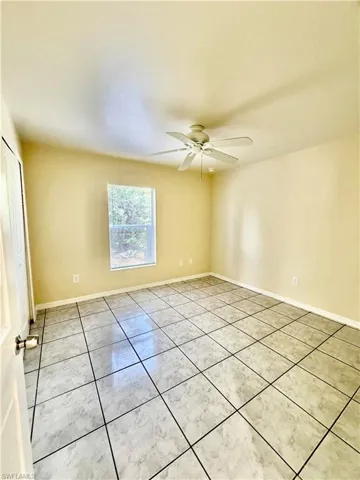 Unfurnished room with a ceiling fan and light tile patterned flooring