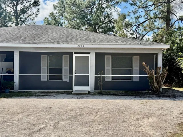 View of front of property featuring roof with shingles and a sunroom