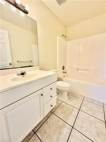 Full bath with vanity, shower / bathtub combination, and light tile patterned floors