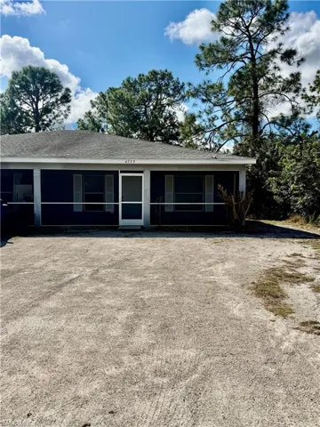 View of front of property with a sunroom and a shingled roof
