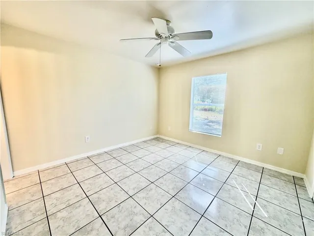 Unfurnished room with light tile patterned flooring and ceiling fan
