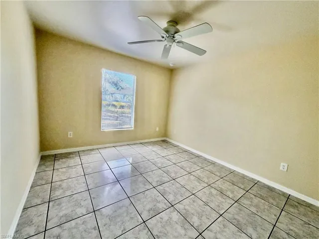 Unfurnished room featuring light tile patterned floors and a ceiling fan