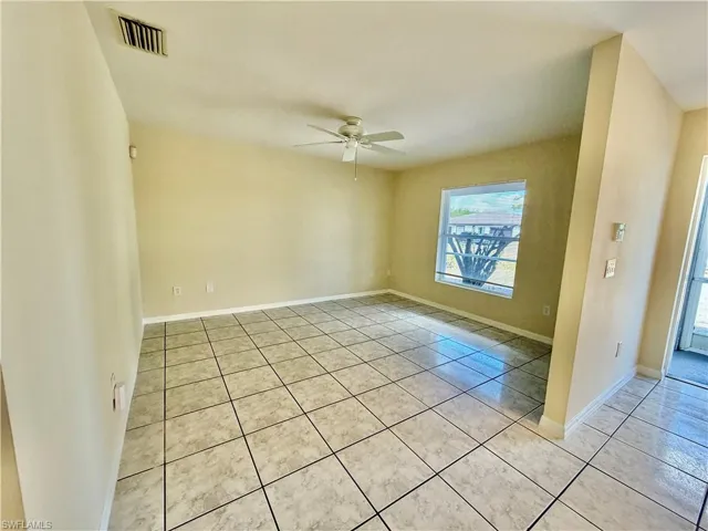 Empty room featuring a ceiling fan and light tile patterned floors
