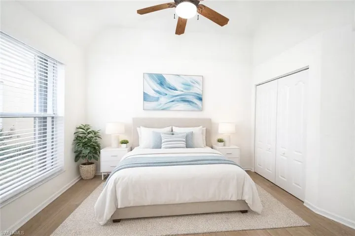 Bedroom with light wood-style flooring, a ceiling fan, vaulted ceiling, and a closet