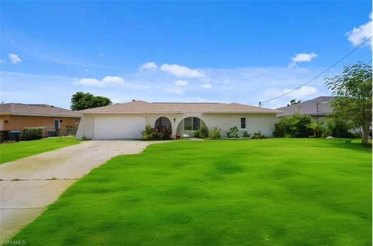 Single story home with a front lawn and a garage