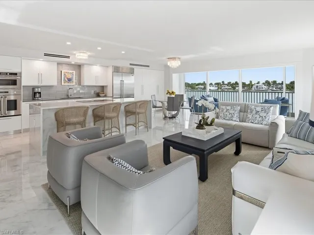 Living area with a chandelier, light marble finish floors, a water view, and recessed lighting