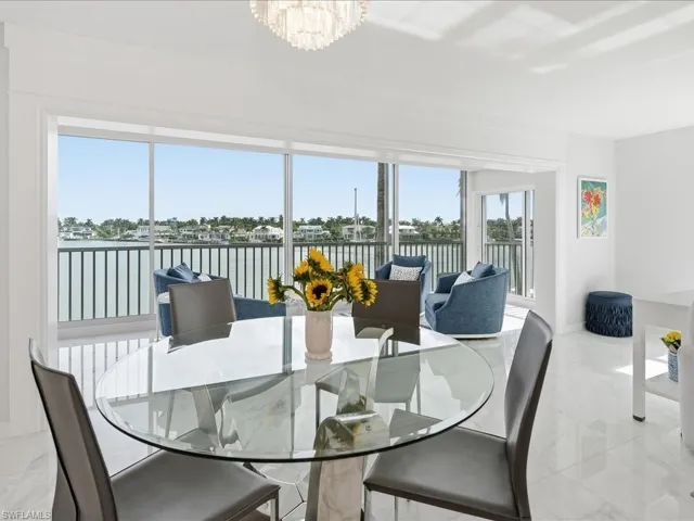 Dining area featuring a water view and light marble finish flooring