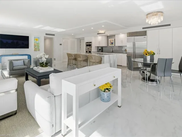 Living room featuring light marble finish floors, a chandelier, and recessed lighting