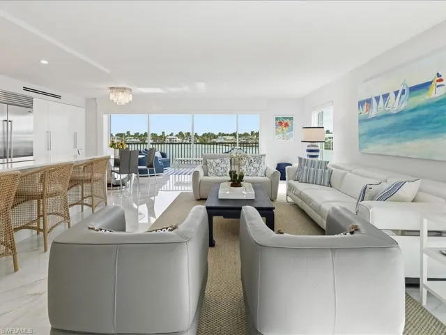 Living area featuring light marble finish floors, healthy amount of natural light, a chandelier, a water view, and recessed lighting