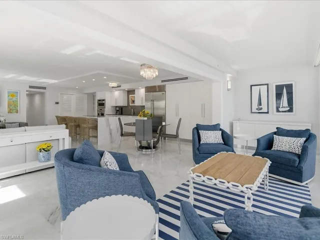 Living room featuring a chandelier, light marble finish flooring, and recessed lighting