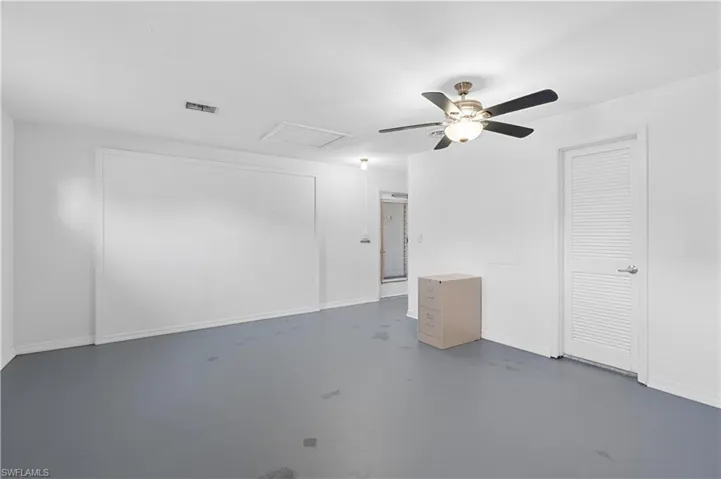 Unfurnished Flex Studio room featuring concrete floors, attic access, and a ceiling fan