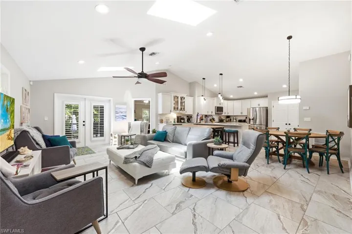 Spacious living area featuring vaulted ceilings, recessed lighting, and skylights