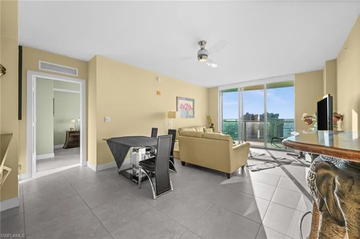 Tiled living room with expansive windows and ceiling fan