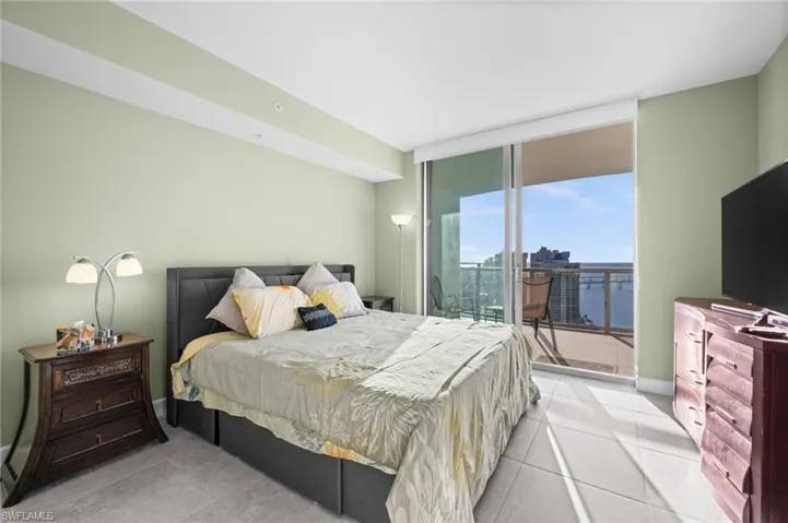 Bedroom featuring floor to ceiling windows, access to outside, and light tile patterned floors