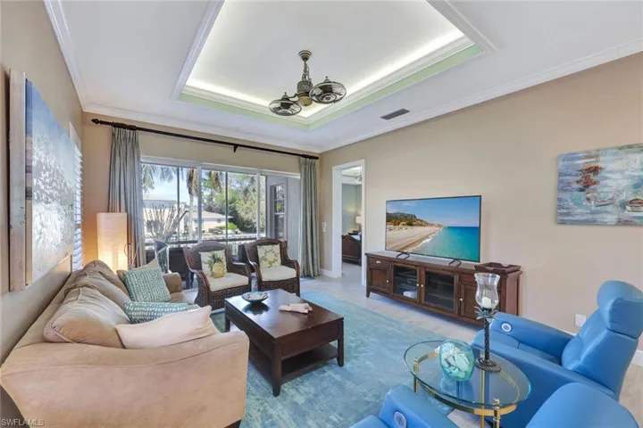 Great room with volume ceilng, tray ceiling detail, unique ceiling fan with light. Accent lighting in the tray ceiling.