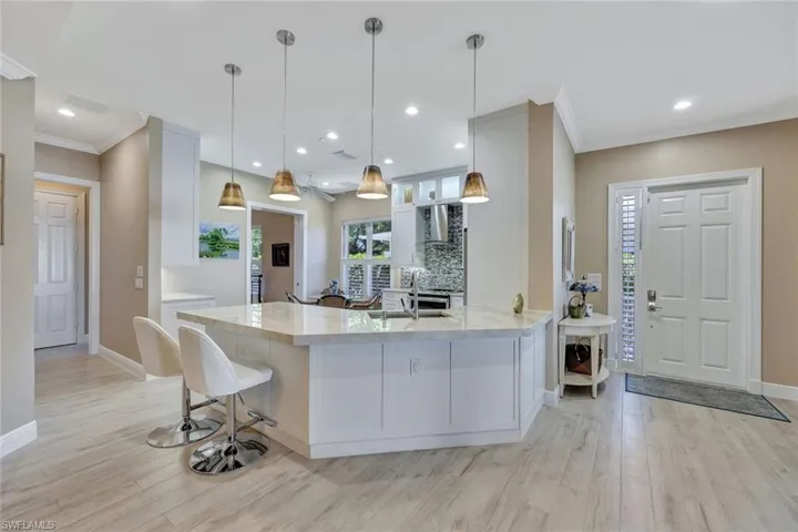 Kitchen featuring white cabinets, kitchen peninsula, nice breakfast bar area. Added storage.