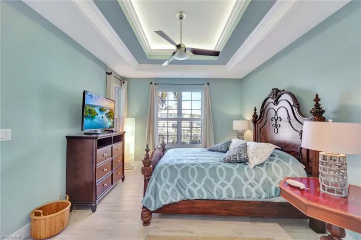 Primary bedroom with tray ceiling detail, crown moldings and accent lighting.
