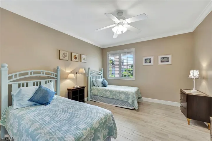 Bedroom with ceiling fan, ornamental molding, and a good size walk-in closet.