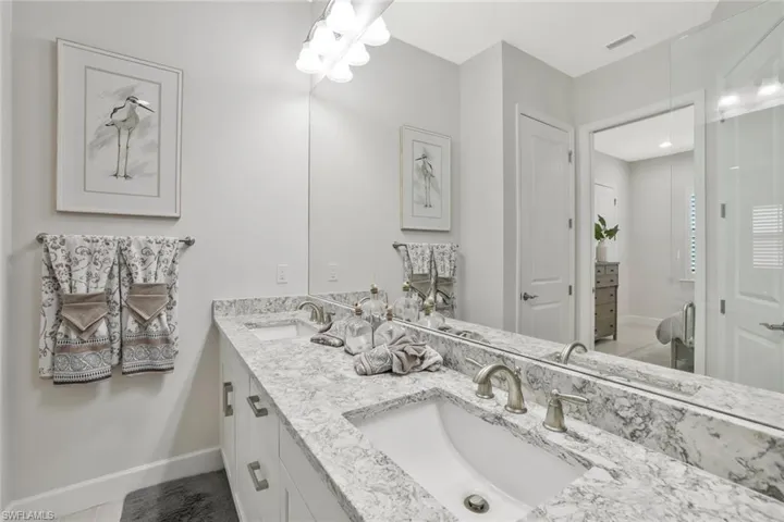 Bathroom featuring double vanity and baseboards