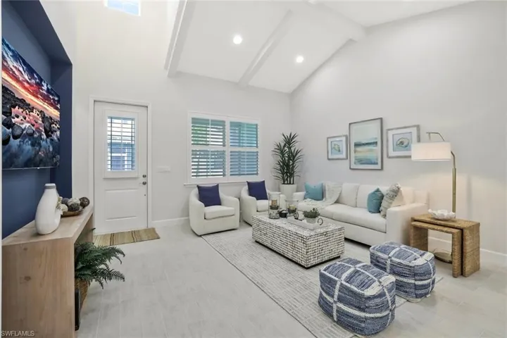Living room with beamed ceiling, high vaulted ceiling, light wood finished floors, and recessed lighting