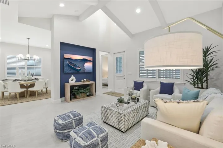Living area with high vaulted ceiling, a chandelier, wood finished floors, beamed ceiling, and recessed lighting