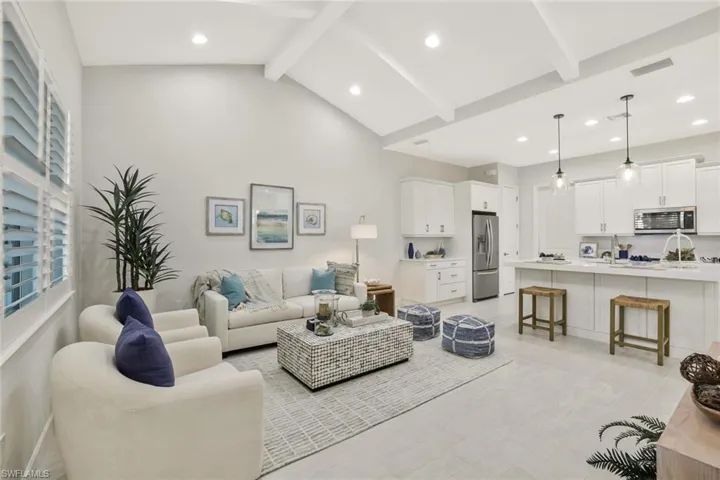 Living area with beamed ceiling, recessed lighting, and high vaulted ceiling