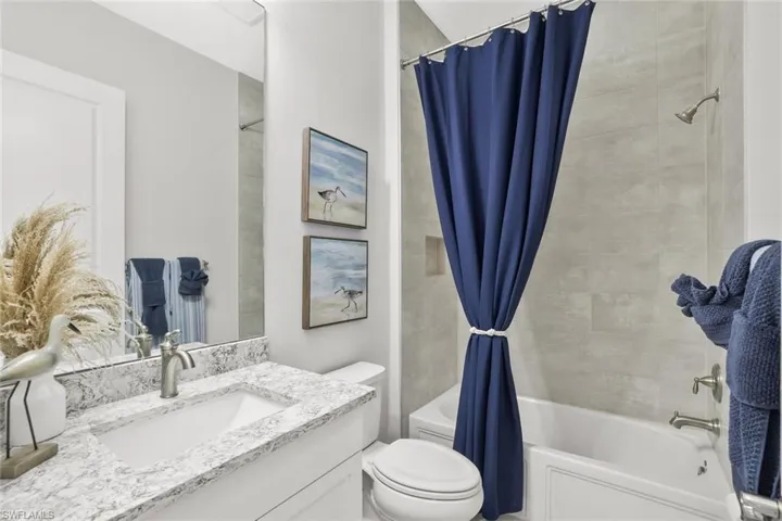 Bathroom with shower / bathtub combination with curtain and vanity