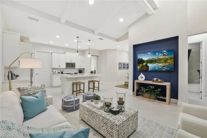Living room with beam ceiling, recessed lighting, and high vaulted ceiling
