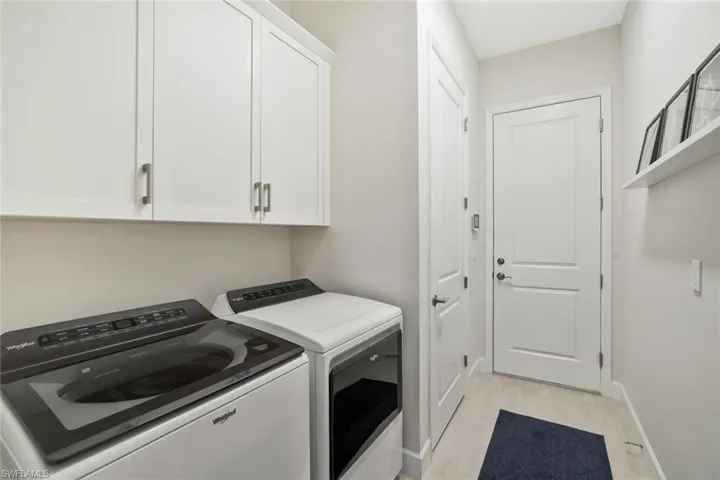 Laundry area featuring washing machine and clothes dryer and cabinet space
