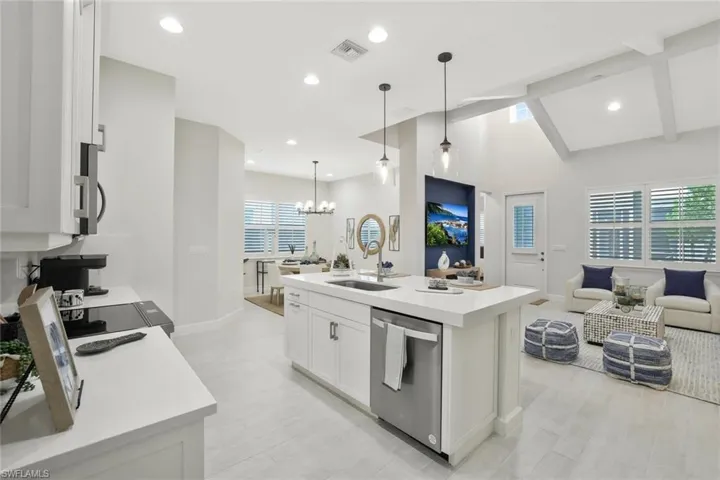Kitchen featuring open floor plan, white cabinets, recessed lighting, stainless steel appliances, and a kitchen island with sink
