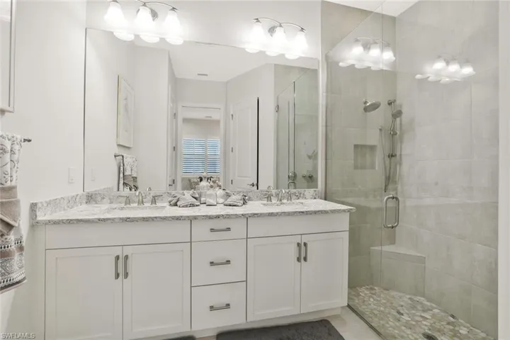 Full bath with double vanity and a stall shower