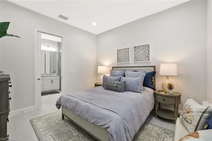 Bedroom with connected bathroom and recessed lighting