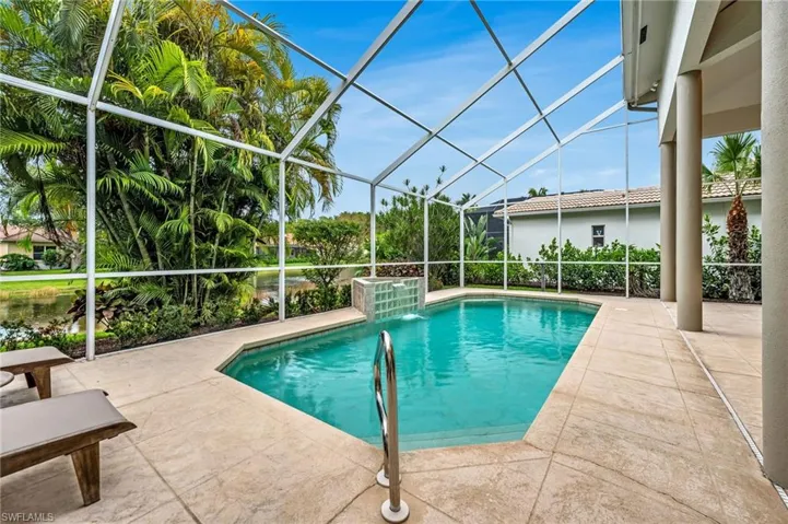 Screened enclosure featuring a geometric pool with water feature, concrete patio, and substantial architectural columns