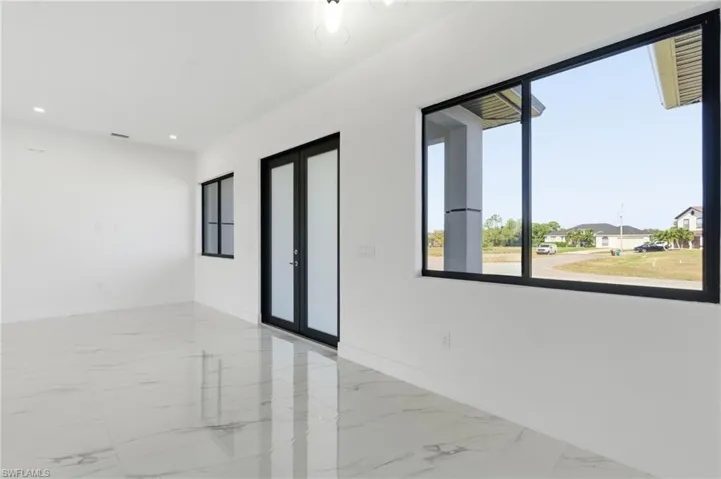 Spare room featuring light marble finish flooring, french doors, and recessed lighting