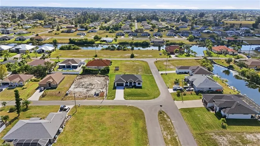 Aerial perspective of suburban area featuring a nearby body of water